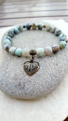 A gentle energy emanates from this "Connection" bracelet in aqua terra jasper. It will help you keep a positive state of mind, regain hope if you no longer have any, it will bring you peace, harmony and a feeling of compassion for others and for yourself. Composed of 21 aqua terra jasper beads, decorated with small bronze-colored metal beads and a pretty heart-shaped "love" medal. Dimensions: approximately 18 cm (can be adjusted on request, other sizes possible on order) Because you are unique, Releasing Negative Energy, Pretty Heart, Aqua Terra, Robins Egg, Jasper Beads, Healing Powers, State Of Mind, Bronze Color, Metal Beads