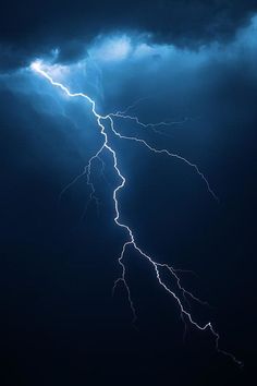 a lightning bolt is seen in the dark sky