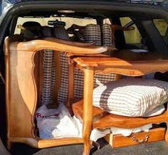 the back end of a car with furniture in the trunk and luggage on the floor