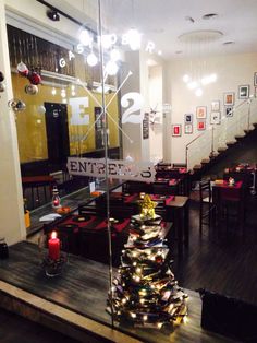 a christmas tree sitting in the middle of a dining room next to a stairwell way