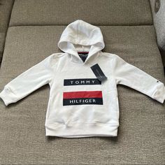 Brand New With Tags Sporty Long Sleeve Sweatshirt For Playtime, White Cotton Hoodie For Playtime, Sporty Long Sleeve Hoodie For Playtime, White Cotton Hoodie For Casual Wear, Tommy Hilfiger Hooded Tops For Winter, Winter Hooded Tops By Tommy Hilfiger, Tommy Hilfiger Hooded Winter Tops, Winter Hooded Tommy Hilfiger Tops, White Winter Hoodie For Playtime