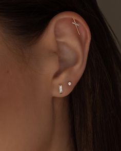 a close up of a person's ear with two piercings on top of it