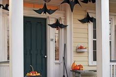 the front porch is decorated for halloween with bats and pumpkins hanging from the ceiling