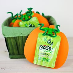 two plastic pumpkins sitting next to each other in a green planter with tags on them