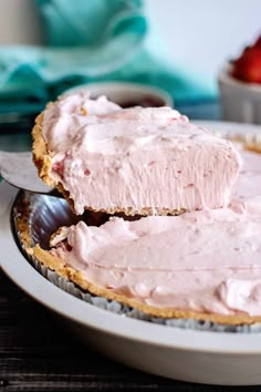 a close up of a pie on a plate with a spoon and bowl in the background