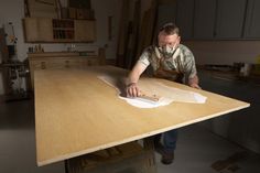 a man sanding down a wooden table top