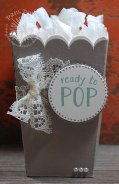 a paper bag with some doily on it and the words ready to pop in green