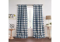 a blue and white checkered curtain hanging in front of a window with a lamp