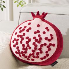 a pomegranate pillow sitting on top of a couch