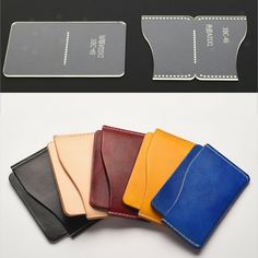 four different colored leather wallets and one has a credit card holder on top of it