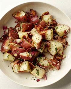 a white bowl filled with potatoes and bacon