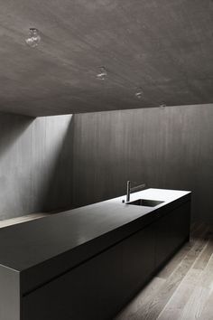 an empty kitchen with a sink and counter top in the middle of the room,