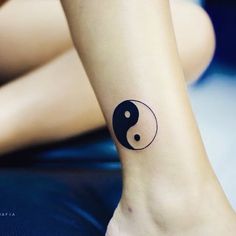 a woman's foot with a small tattoo on the side of her leg, which has a ying - pei symbol