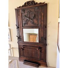 an ornate wooden armoire with mirror on top