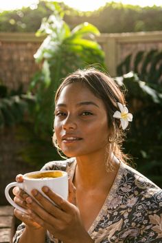 a woman holding a cup of coffee in her hands