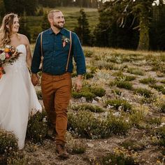 a bride and groom walking through the woods holding each other's hands as they walk together