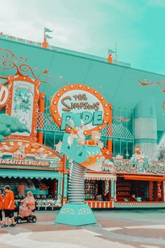 an amusement park with people standing in front of it