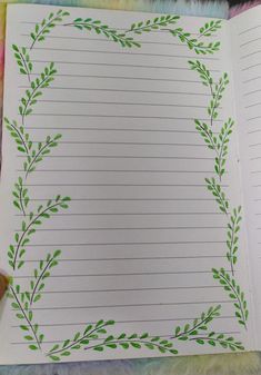 an open notebook with green leaves on it and lined paper in the bottom right corner