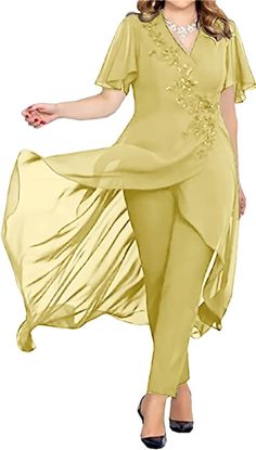 a woman in a yellow dress and pants