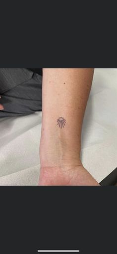 a small flower tattoo on the ankle