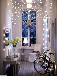 a bicycle parked in front of a window with christmas lights hanging from it's sides