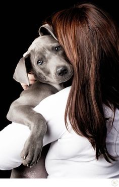 a woman holding a dog up to her face with the caption, i am not sure what this is