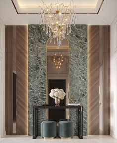 an elegant foyer with marble walls and chandelier