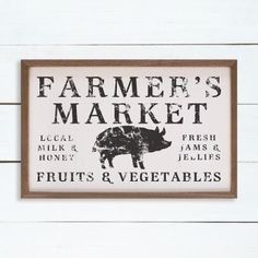 a sign that says farmer's market on the side of a white wooden wall