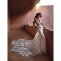 a woman in a wedding dress leaning against a wall