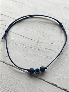 This gorgeous wax cord bracelet is finished in dark blue and is fully adjustable so will fit any sized wrist. It features a glass evil eye bead with 2 darker blue beads to both sides. 💕Unisex so anyone can wear 💝It is presented on a white A6 card, with an explanation on the evil eye. - “The evil eye is a curse believed to be cast by a malevolent glare, usually given to a person when they are unaware. Many cultures believe that receiving the evil eye will cause misfortune or injury. Talismans t Jewelry Evil Eye, Plastic Gift Wrap, Wax Cord Bracelet, Spiritual Bracelets, Glass Evil Eye, Bracelet Evil Eye, Eye Gift, Protection Bracelet, Cord Bracelet