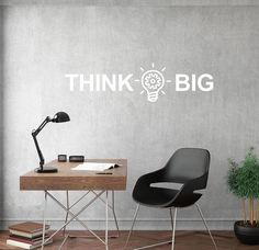 an office with a desk and chair in front of the wall that says think big