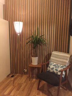 a chair and table in a room with wood paneling on the wall behind it