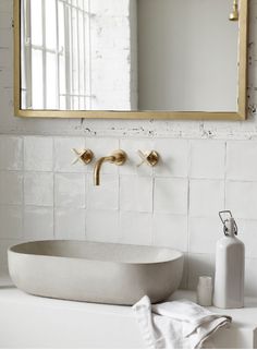 a bathroom with a sink, mirror and soap dispenser