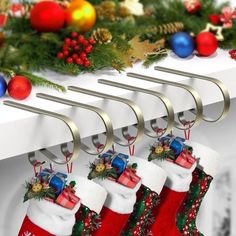 three christmas stockings hanging from hooks on a shelf