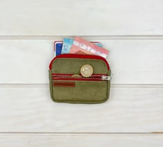 a green purse with some money in it on a white wooden surface and the bottom half is empty