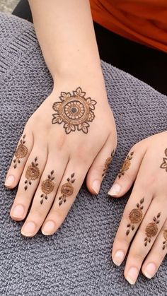 two hands with henna tattoos on them