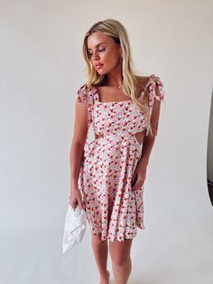 DETAILS: Our Olivia Floral Cut Out Mini Dress is definitely a MUST HAVE for your wardrobe this spring and summer! This dress features a floral pattern, side cut outs, flowy skirt (that is lined), self tie adjustable shoulder straps, self tie back detail, and has a hidden back seam zipper closure with a hook and eye clasp. CONTENT & CARE: SELF: 100% Cotton. LINING: 100% Rayon. SIZE & FIT: Model is 5'5" The model is wearing a size small Fits true to size The Fabric has stretch Summer Floral Dress With Spaghetti Straps For Brunch, Spring Sundress With Tie Straps For Day Out, Spring Dress With Adjustable Straps For Brunch, Spring Brunch Dress With Adjustable Straps, Beach Sundress With Knotted Straps For Spring, Summer Garden Party Dresses With Knotted Straps, Summer Floral Square Neck Dress For Brunch, Summer Floral Dress With Square Neck For Brunch, Chic Floral Dress With Spaghetti Straps For Spring