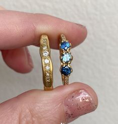 A trio of shades of mismatched deep blue sapphires with a dusting of G/VS diamonds in the band. Each sapphire measures 3.25 - 3.5mm. Diamond weight 0.03ct. Band measures 1.5mm approximately. Approximate gold weights: 1.7g in 9ct, 1.9g in 14ct, 2.1g in 18ct. Pictured here with a matte finish. For a high shine finish please leave a note at checkout. 14k Gold Blue Rings With Single Cut Diamonds, Blue Sapphire Ring With Three Stones, Sapphire Ring With Single Cut Diamonds As Gift, Blue Sapphire Ring With Single Cut Diamonds For Promise, Fine Jewelry Blue Sapphire Ring With Single Cut Diamonds, Blue Sapphire Three-stone Promise Ring, Blue Three Stone Sapphire Promise Ring, Blue Sapphire Promise Ring With Single Cut Diamonds, Heirloom Blue Sapphire Promise Ring