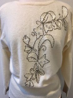 "White Lambswool Angora Pullover Sweater with Beaded Embroidered Leaf Design, by Renee Tener for Jeanne Pierre Size Medium This sweater is almost perfect except for 1 small mend job (pic no. 8) Features are a 3\" sock bottom along with end of sleeves, shoulder pads that can be removed and a beautiful beaded embroidered design on the front. The tube beads look like a dark silver and they edge the design that is filled with shimmery white embroidery stitches and also silver stud like beads. Really Elegant White Embroidered Sweater, Elegant Floral Embroidered Tops For Winter, Elegant Embroidered Winter Sweater, Elegant Embroidered Winter Tops, Job Pic, Job Pictures, Embroidered Leaf, Embroidered Leaves, Beautiful Cookies