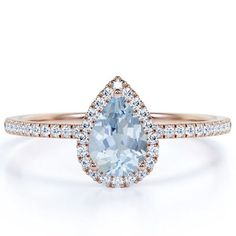 an engagement ring with a pear shaped aqua blue topazte surrounded by white diamonds