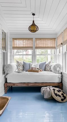 a room with blue flooring and white walls, including a bed in the corner