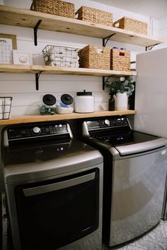 a washer and dryer in a small room with shelves on the wall behind them