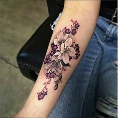 a woman's arm with flowers on it, and the tattoo is done in black ink