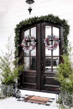 two wreaths on the front door of a house