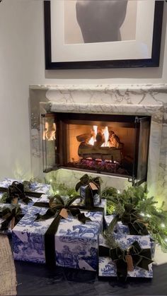 presents are wrapped in blue and white paper next to a fireplace