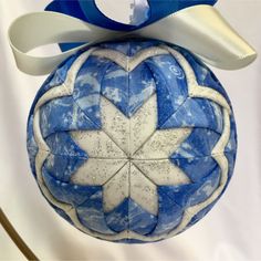 a blue and white ornament with a bow on it's head hanging from a hook