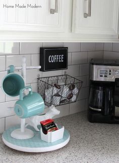 a coffee maker sitting on top of a kitchen counter next to a cup holder and basket