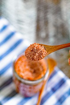 a person holding a wooden spoon with some food on top of it in their hand