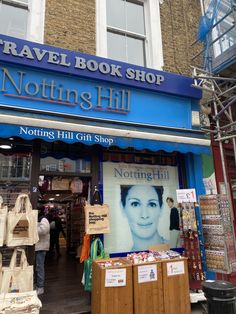 there is a sign that says notting hill in front of a store with an advertisement on it