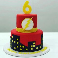 a red and yellow birthday cake with the number six on it's top tier